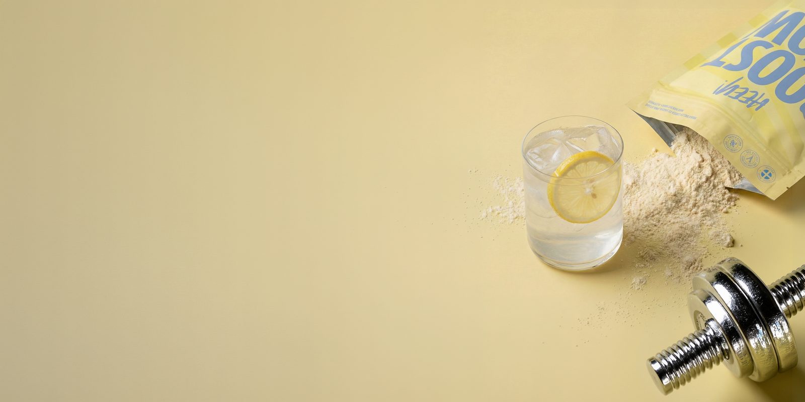 Heey! Boost & Glow Lemon med Coll-egan® vegansk kollagenbyggare, glas med citron och hantel, klarar checklistan för kollagentillskott