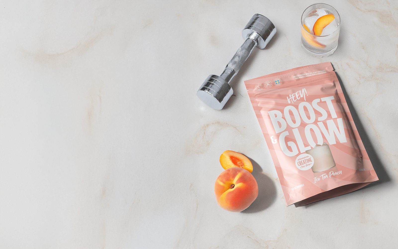 Heey! Boost & Glow med Coll-egan® vegansk kollagenbyggare och kreatin, flatlay på marmor med hantel och persika