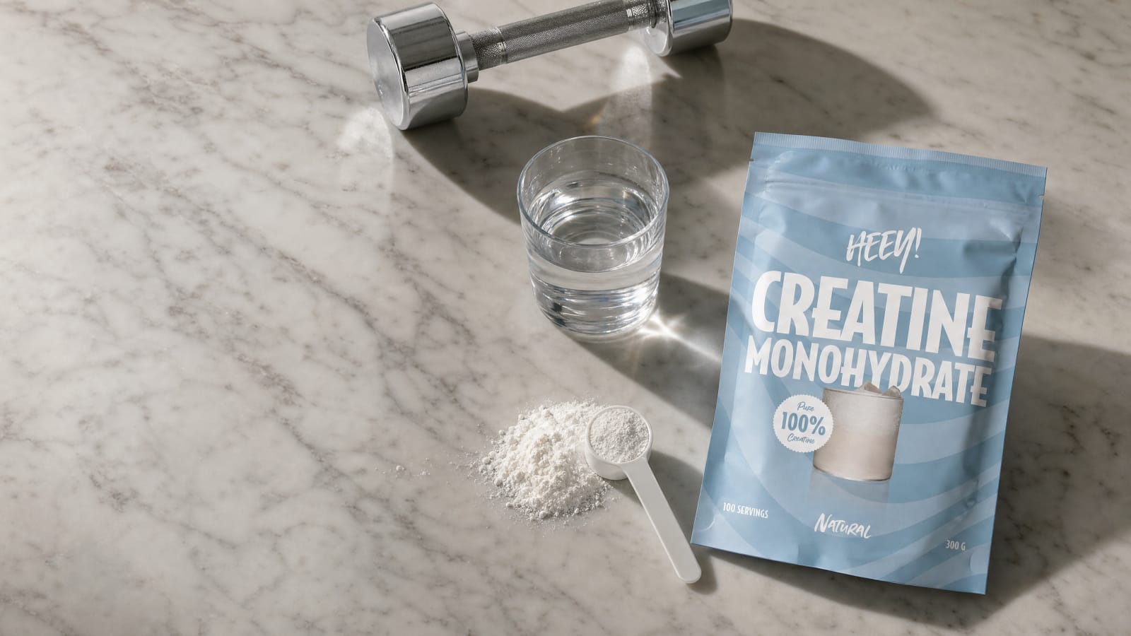Heey! Kreatin Monohydrat på ljus marmor med ett glas vatten, kreatinpulver med mätsked och en hantel, rent vegansk kreatinmonohydrat 3 g per dos
