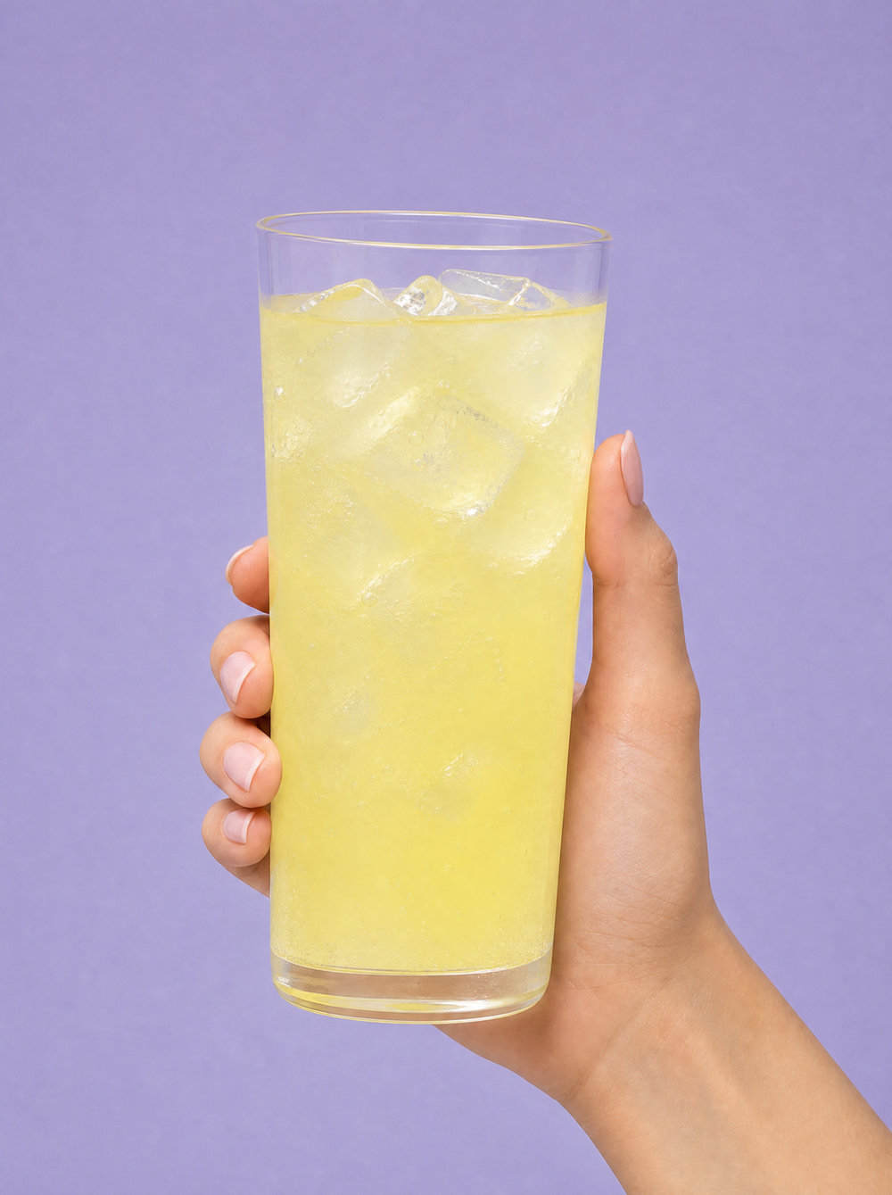 Hydrate & Focus how-to step 3: hand holding a glass of lemonade electrolyte drink